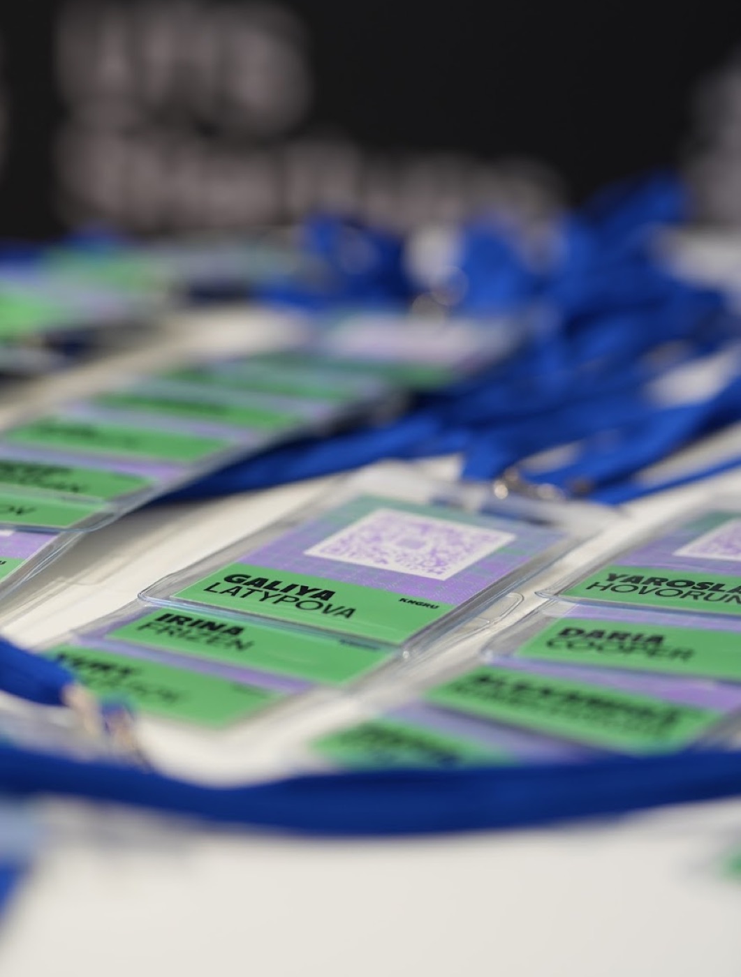 Branded attendee badges with QR codes on blue lanyards